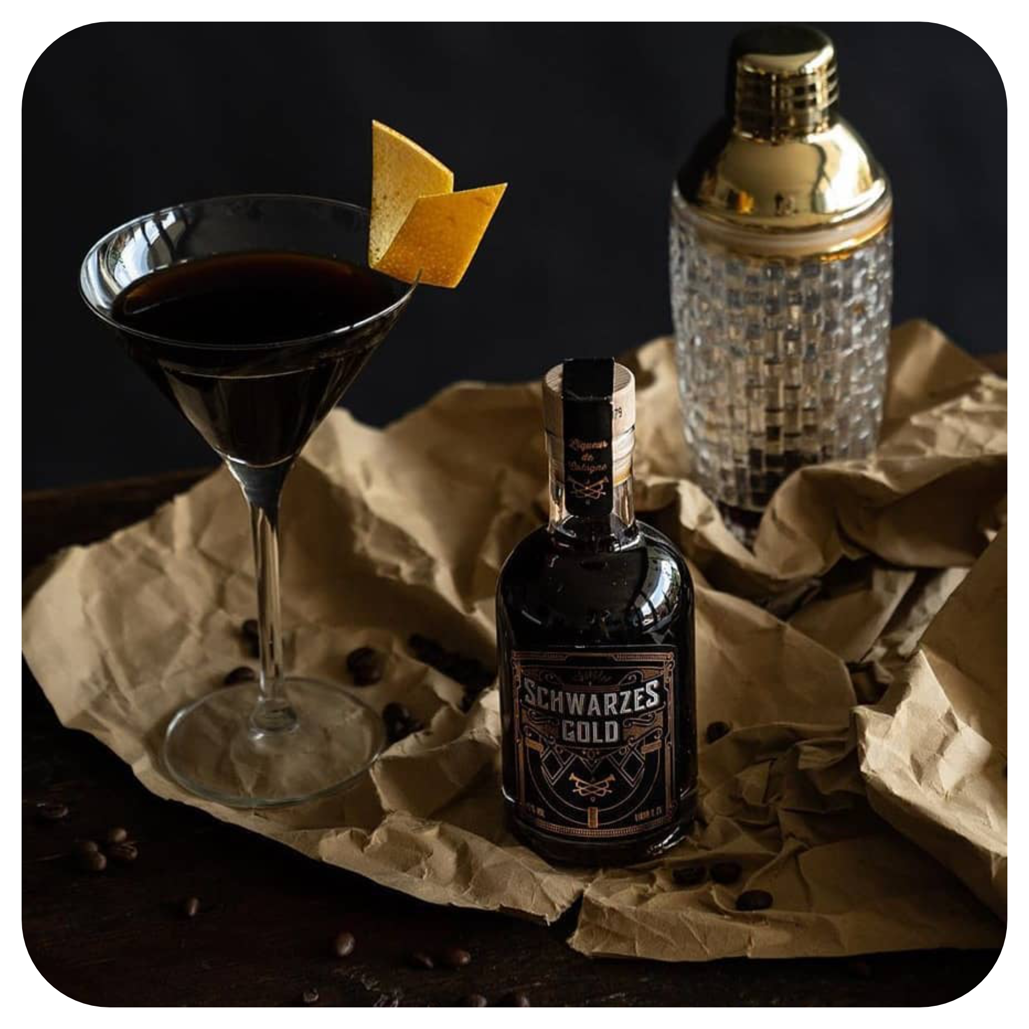 200ml Flasche unseres Espresso-Likörs, serviert neben einem Espresso-Martini mit Zitronengarnitur und Cocktail-Shaker, ideal für Kaffeelikör-Cocktails, aus Bio-Fairtrade-Kaffee.